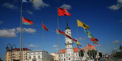 different flags waving on poles at daytime