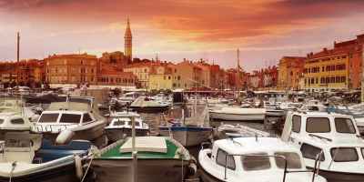 white yachts on body of water during sunset