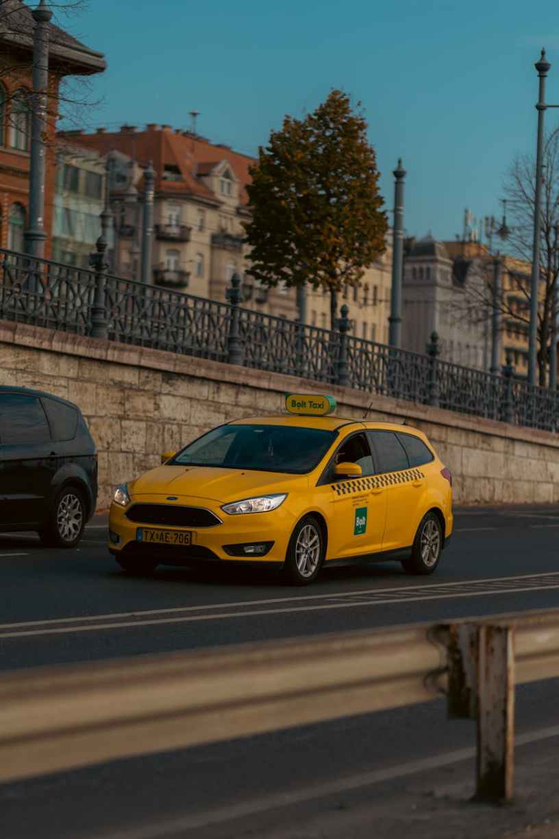 yellow taxi on budapest street with classic architecture