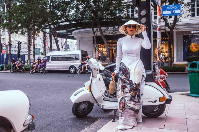 woman standing beside white motor scooter